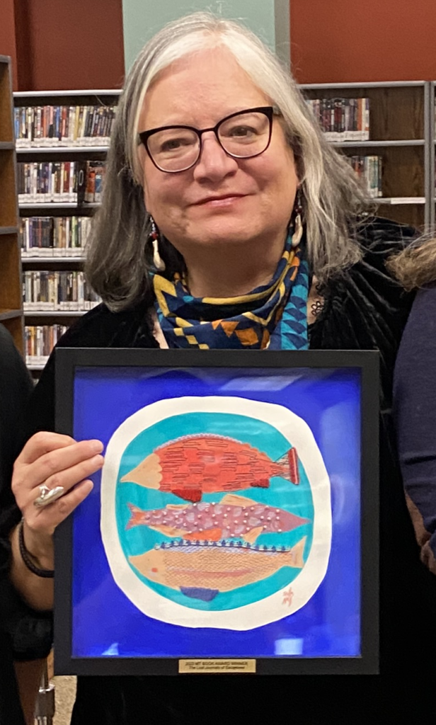 Debra Earling holding artwork by Stella Nall